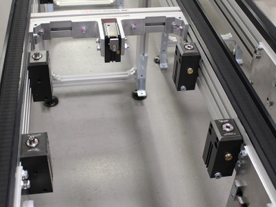 停下来抬起来并找到位置
托盘通过此VersaMove传送机上的气压缸（图像中央背面）停止。然后使用四个前油缸将其抬起并定位。左侧的气缸具有定位销，该定位销与托盘中的存套匹配